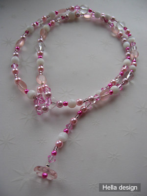 Rosa och vitt p�rlhalsband med �gleslut. 75 cm l�ngt.