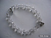 Armband med transparenta facettpärlor och biconer, hjärtberlock och lås i silver. 17,5 cm